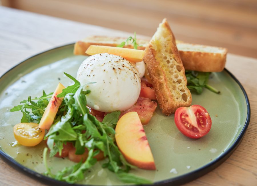 Fresh burrata with tomatoes, rocket salad and toasted bread served at the pool bistro of a wellness hotel in Berchtesgaden