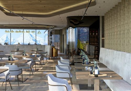 Ein elegantes Restaurant mit modernen Möbeln, großer Fensterfront mit Bergblick, gedeckten Tischen und stilvoller Dekoration.