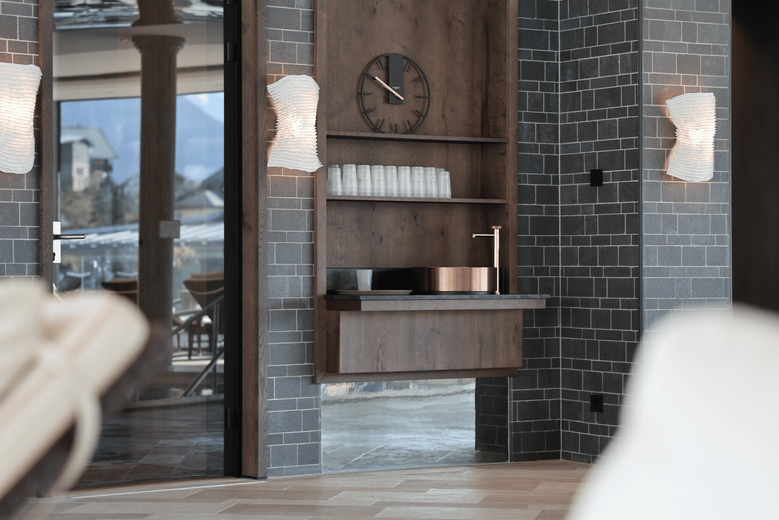Stilvolle Erfrischungsstation in der Wasserwelt des Hotel EDELWEISS Berchtesgaden mit Quellwasser, Bechern und warmen Naturmaterialien für eine entspannte Wellnessauszeit in Bayern