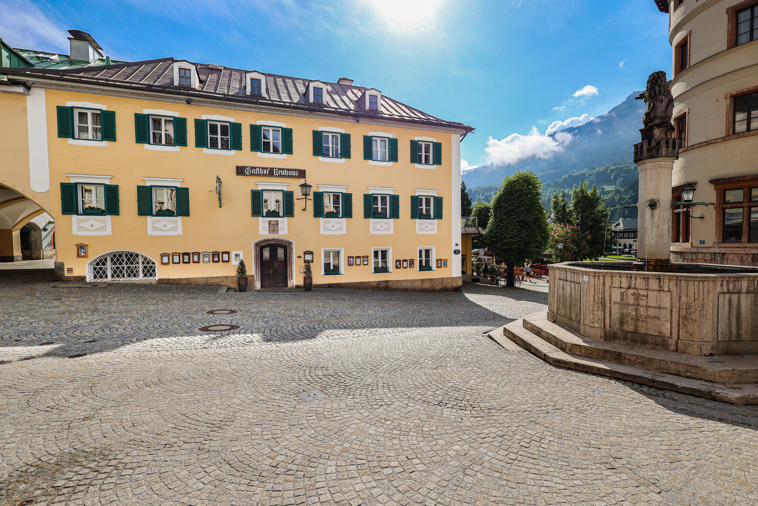 Außenansicht des Gasthof Neuhaus am Marktplatz in Berchtesgaden mit historischem Gebäude und Alpenpanorama