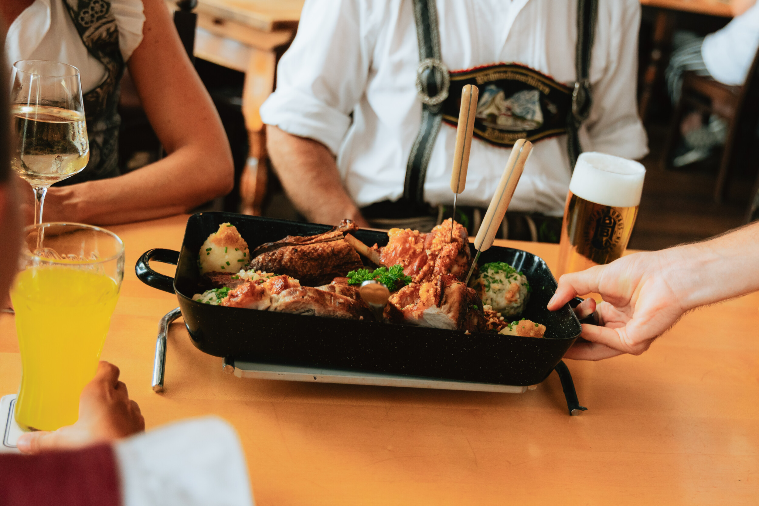 Bayerische Spezialitätenplatte im Gasthof Neuhaus in Berchtesgaden mit verschiedenen Würsten, Fleischvariationen, Haxe, Semmel- und Kartoffelknödeln sowie Krautsalat zum Teilen.