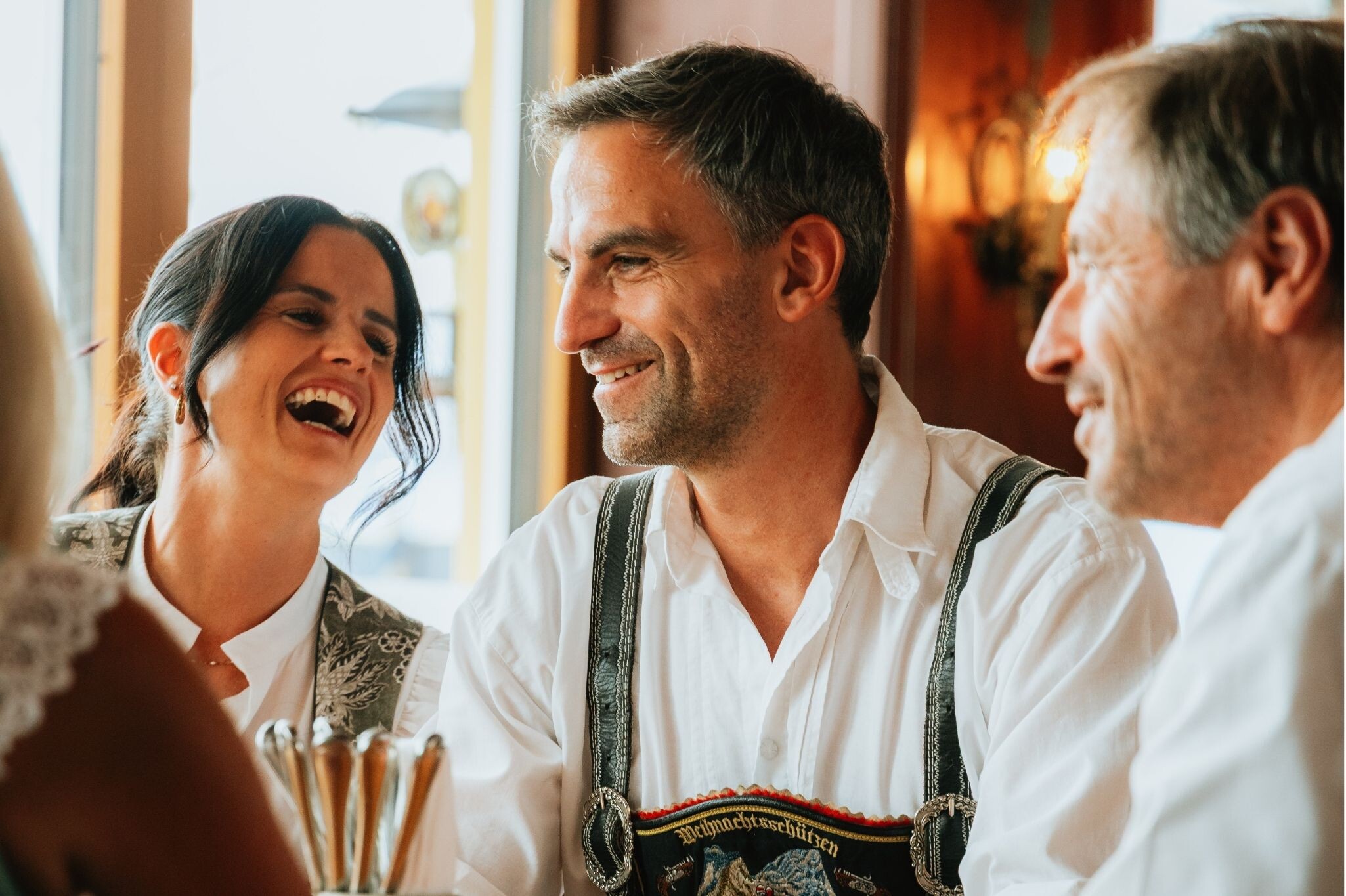 Gäste in bayerischer Tracht in geselliger Runde im Gasthof Neuhaus in Berchtesgaden