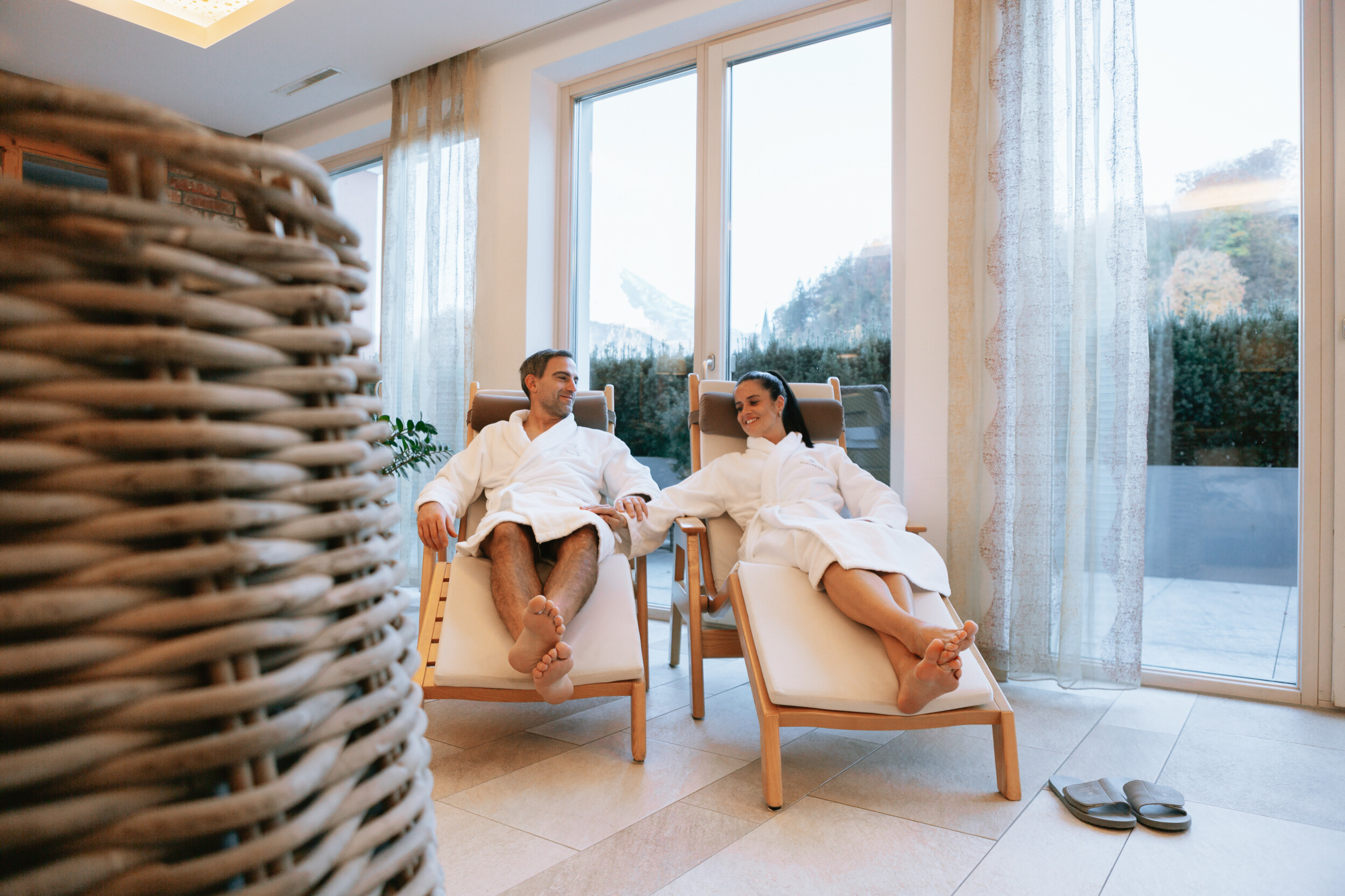 Ruheraum mit komfortablen Liegen, Alpenblick und direktem Zugang zum Außenbereich – pure Entspannung im Wellnesshotel in Bayern.