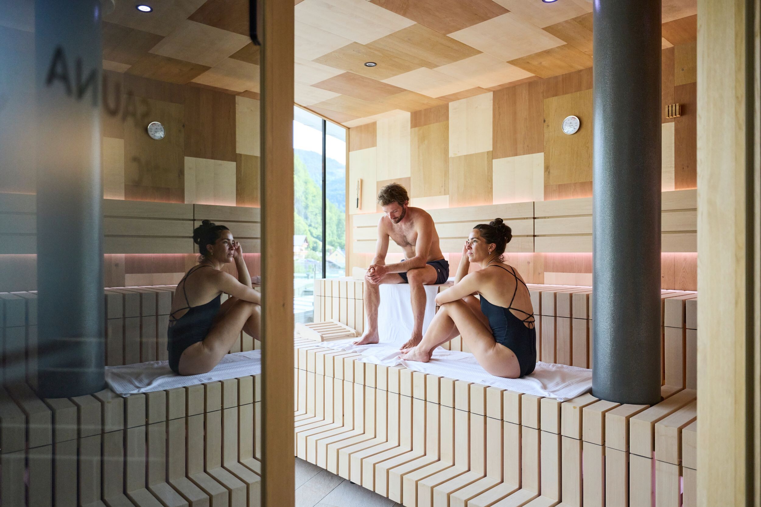 Wellnessgäste entspannen in der modernen Textilsauna des Hotel EDELWEISS Berchtesgaden mit Blick auf die Berchtesgadener Bergwelt.