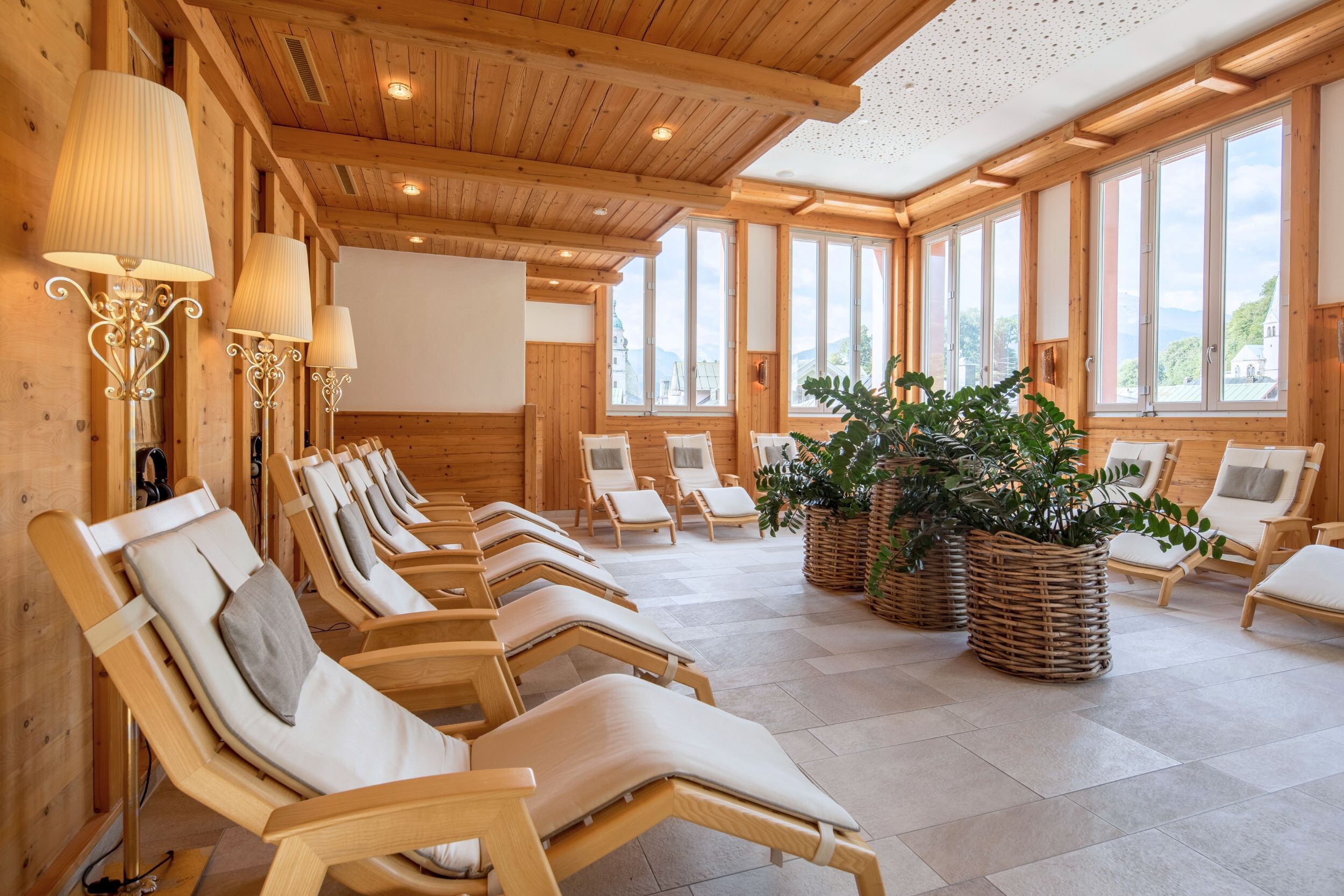 Heller Ruhe- und Saunabereich der Textilsauna im Hotel EDELWEISS Berchtesgaden mit Holzinterieur und Blick in die Bergwelt.