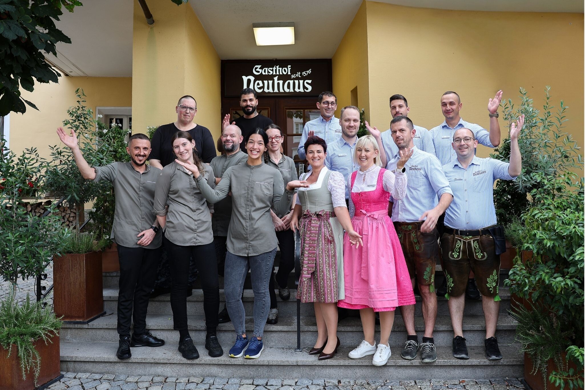 The team of Gasthof NEUHAUS in Berchtesgaden standing together in front of the historic inn