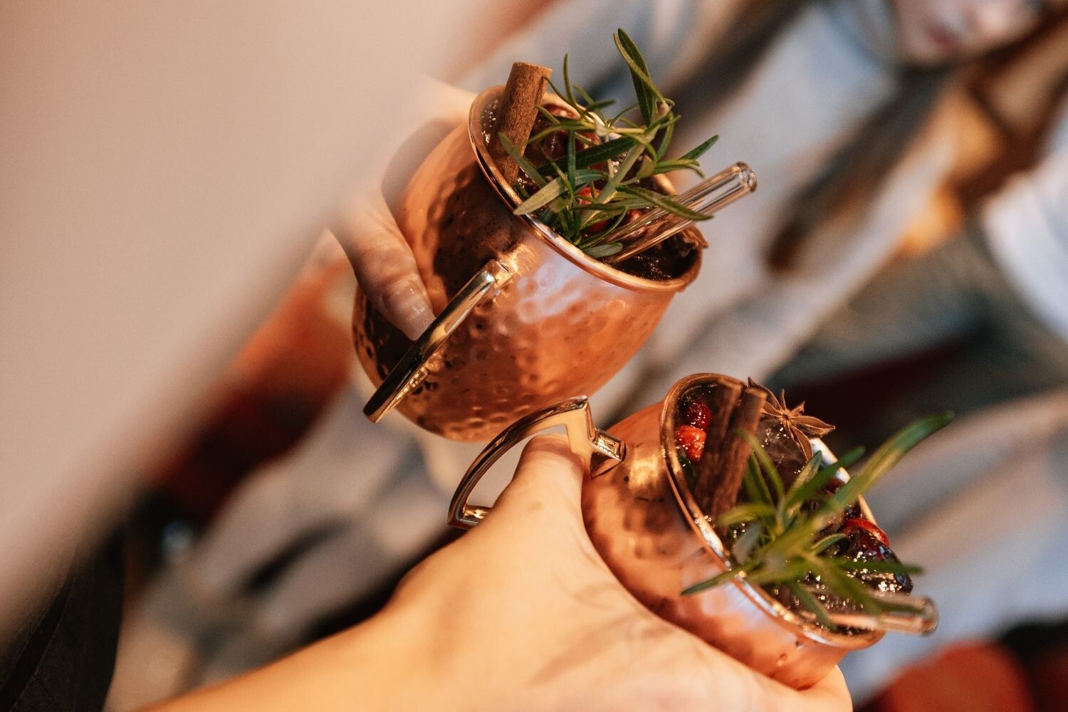 Zwei winterliche Cocktails in Kupferbechern mit Zimt, Rosmarin und weihnachtlichen Gewürzen – festliche Genussmomente im Hotel EDELWEISS Berchtesgaden.