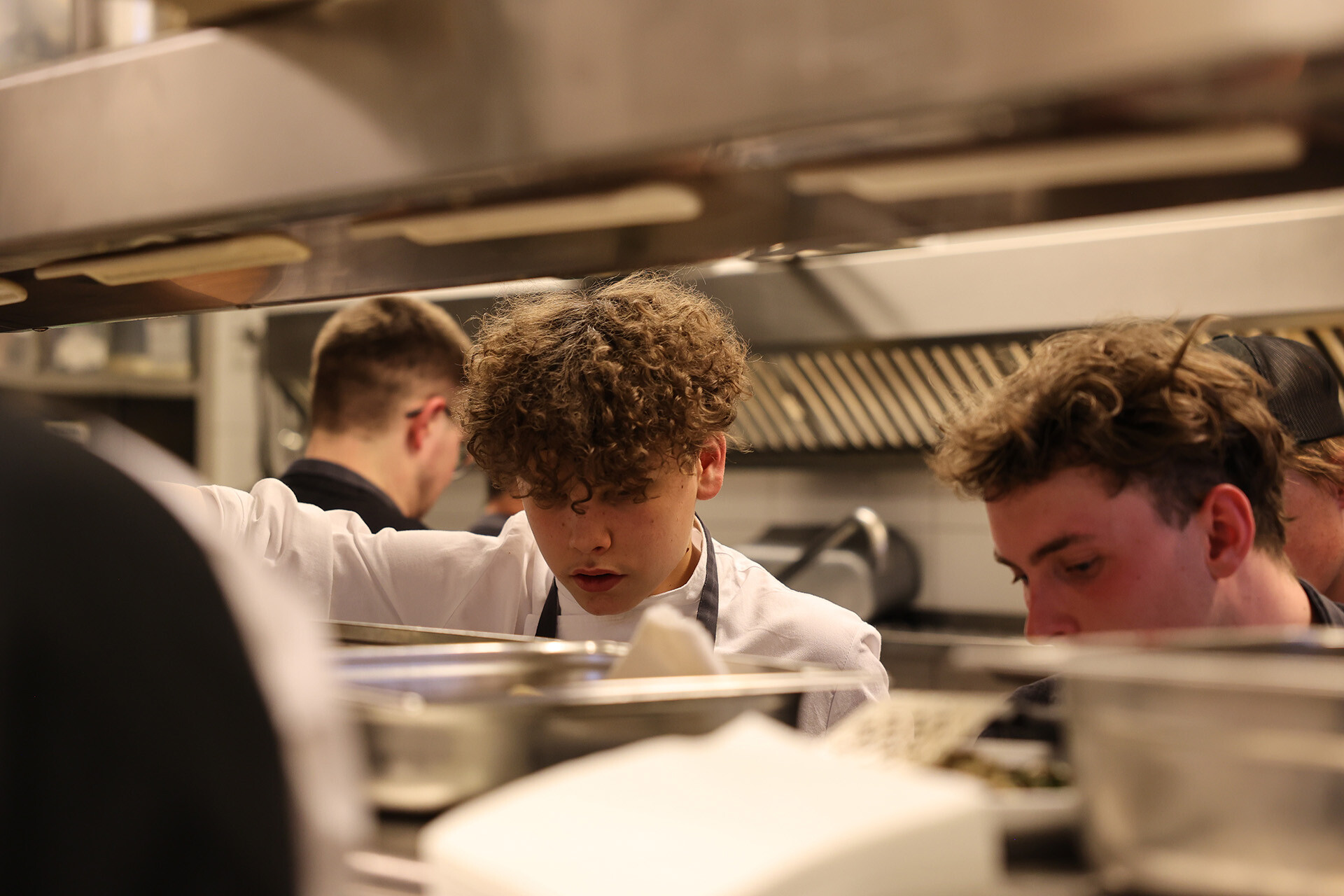 Köche in Ausbildung bereiten das Abendessen in der Küche des Restaurants Panorama im Hotel Edelweiss zu – Qualität in der Küche und engagierte Ausbildung bei einem Top-Arbeitgeber